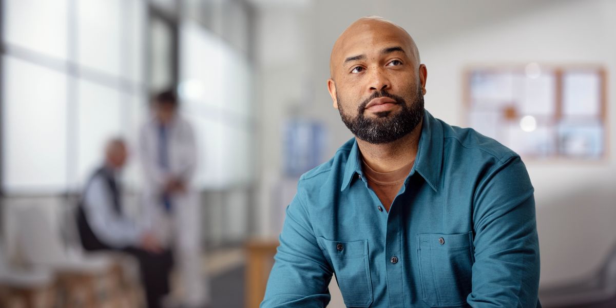 A man waiting in the reception area of a doctor’s office.