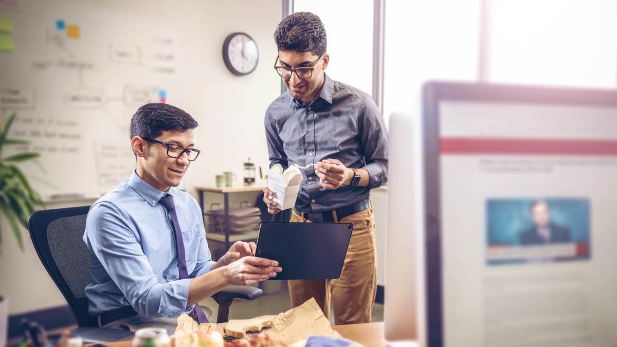 Un hermano predicándole a un compañero de trabajo durante la pausa para el almuerzo.