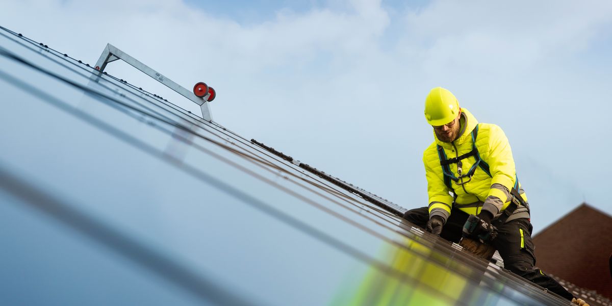 ’n Broer installeer die fotovoltaïse stelsel se panele.