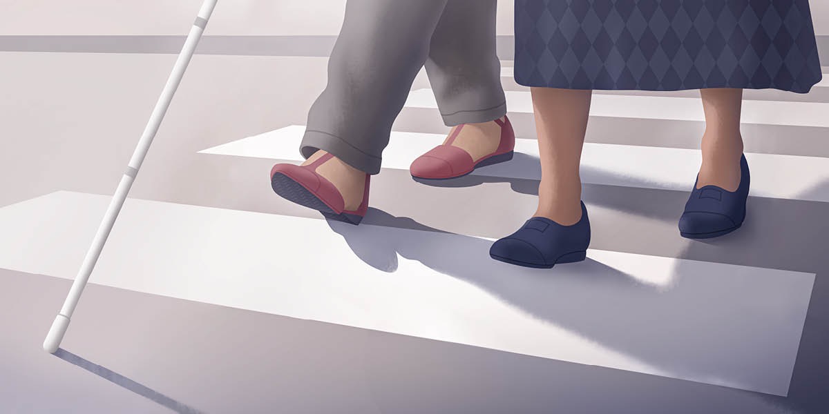 ’n Suster help ’n blinde vrou met ’n wandelstok om oor die pad te loop.