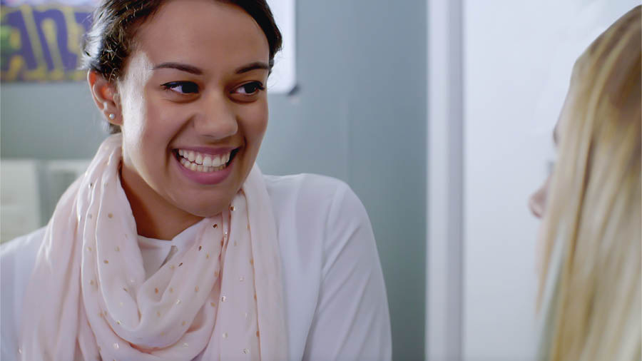 ’n Toneel uit die video “Ervaar die vreugde van die dissipelmaakwerk – Aanvaar Jehovah se hulp – Navorsingshulpe”. Neeta is bly om vir Jade te vertel wat sy in haar navorsing uitgevind het.