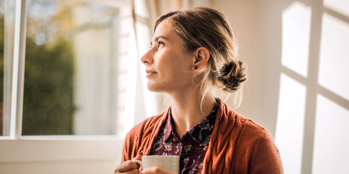 ’n Suster is tevrede en kyk by ’n venster uit.