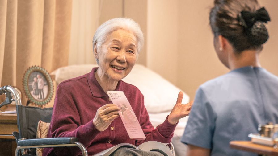 An older wheelchair˗bound sister offers a tract to a health˗care provider