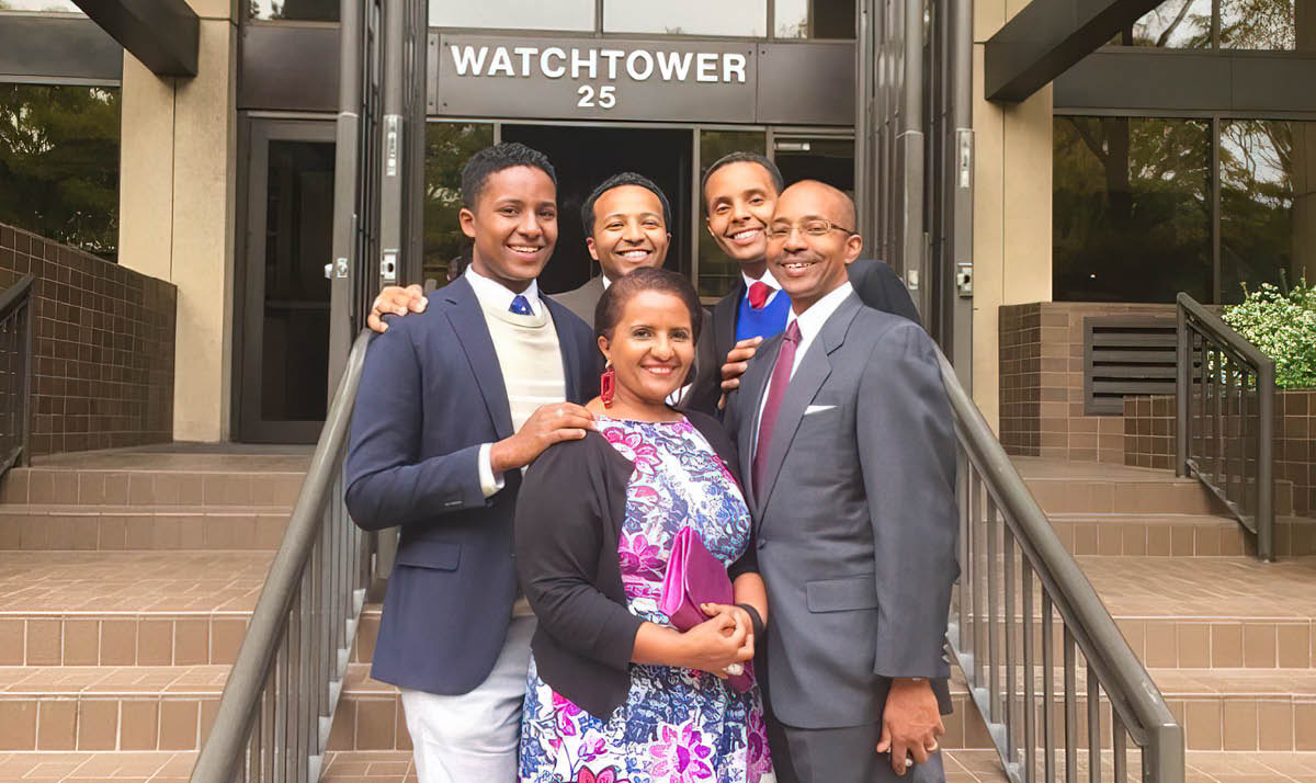 አስቴር፣ ባለቤቷ ዌስሊና ሦስቱ ልጆቻቸው በብሩክሊን ቤቴል በሚገኝ ሕንፃ ፊት ለፊት ፈገግ ብለው ቆመው።