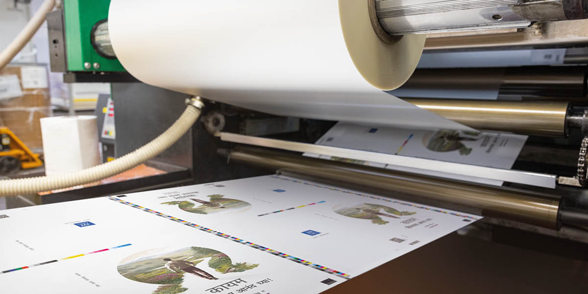 A machine applying a protective film of matte laminate to the covers of the books.