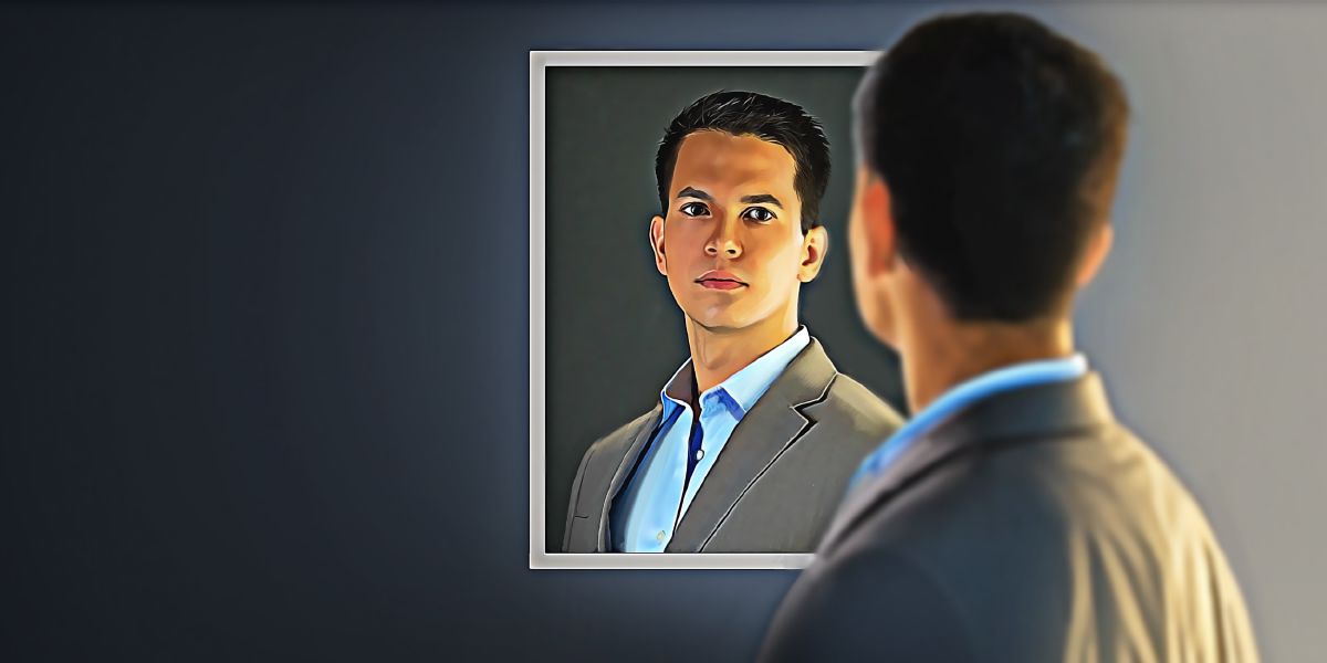 A young man looks at himself in a mirror