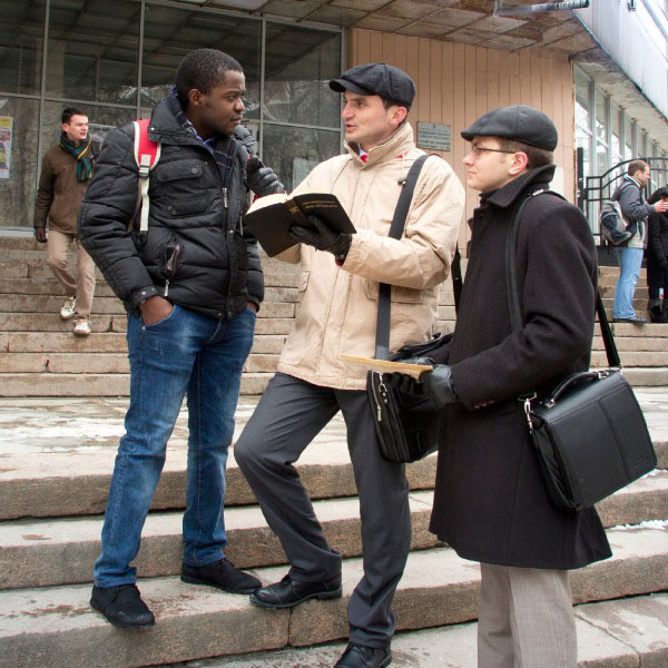 Jehovah’s Witnesses speaking to someone in the public ministry