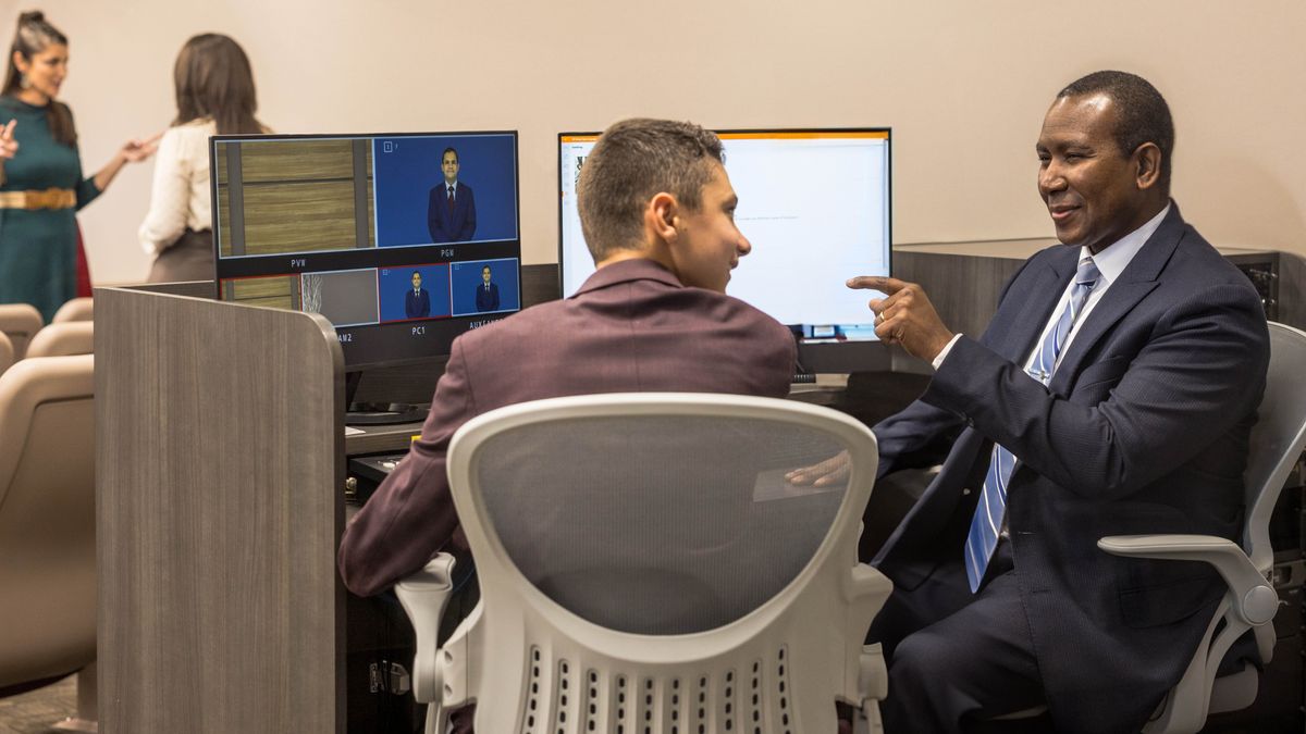 An elder showing a young brother at a Kingdom Hall how to change the batteries in the wireless microphones.