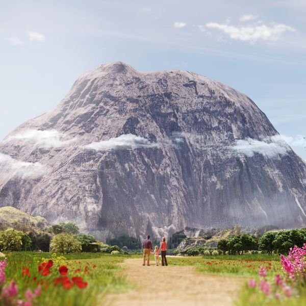 Parents with their young daughter contemplating a large rock mass in front of them.