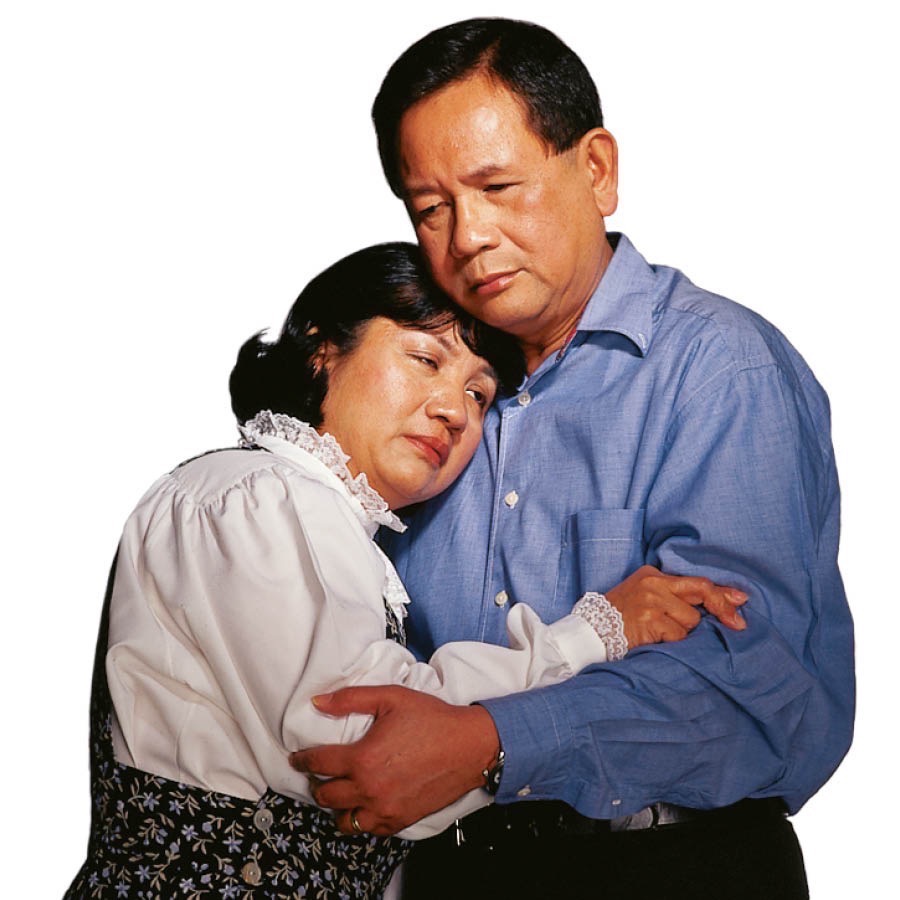 A couple hold each other and grieve