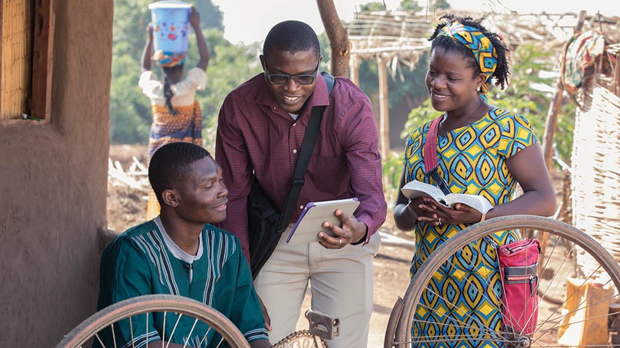 Yehovanın Şahidi olan cütlük təbliğ edir. Onlar bir kişiyə Müqəddəs Kitaba əsaslanan video göstərir.