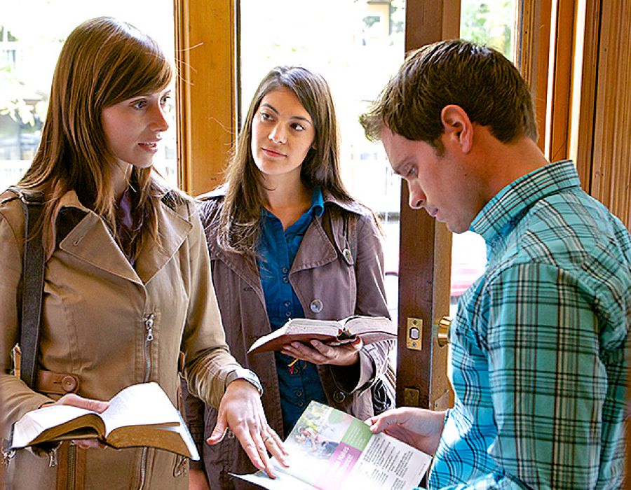 Jehovah’s Witnesses discuss a subject from a magazine with a man