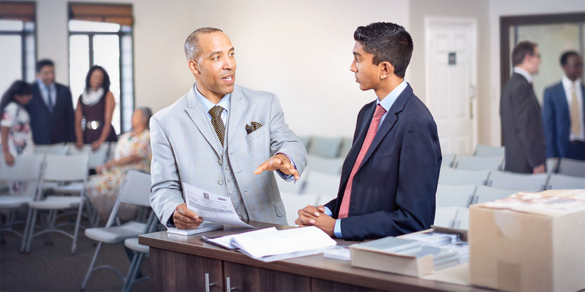 An elder talks with a young brother as he trains him to serve in the congregation