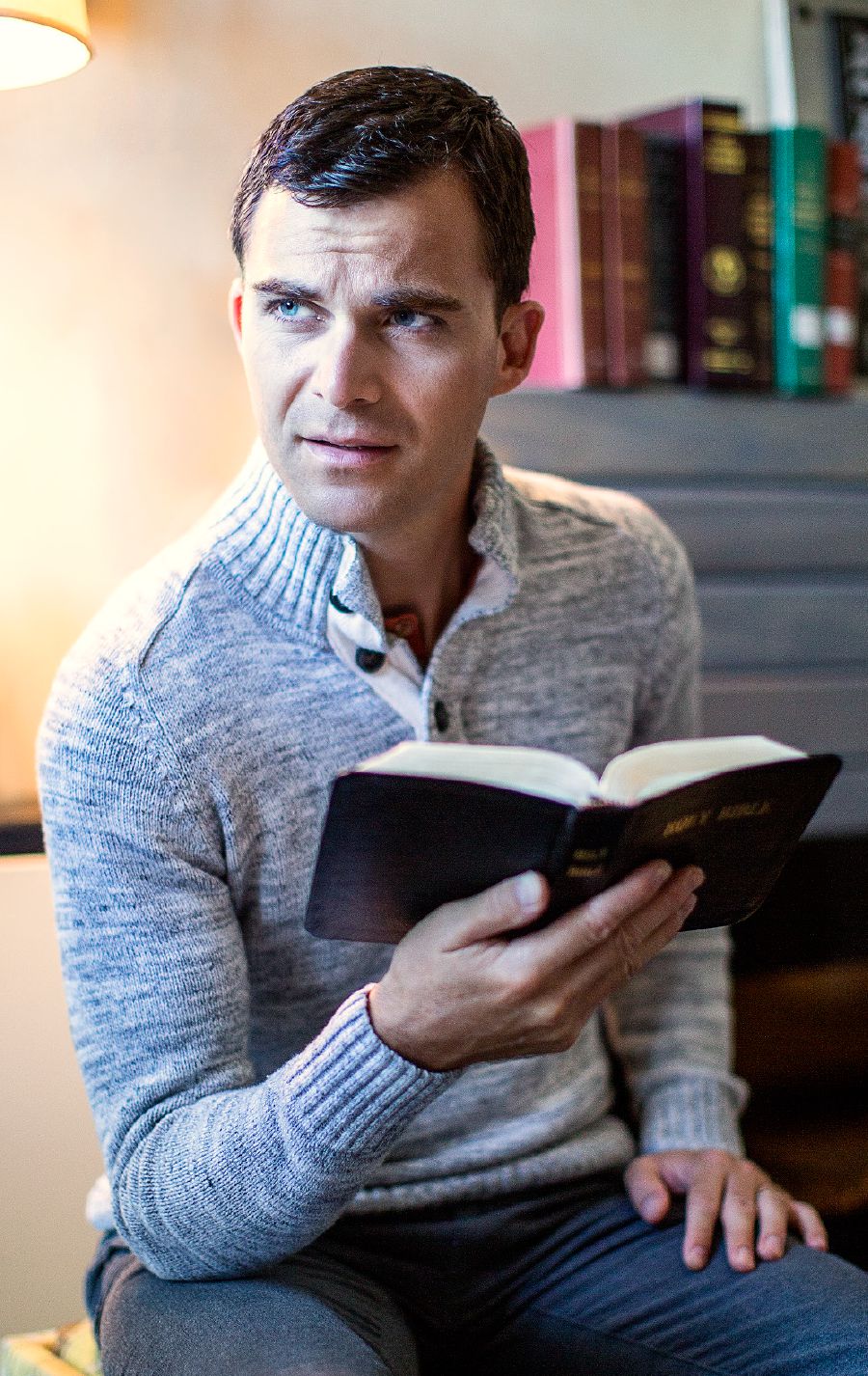 A man holds a Bible and looks skeptical