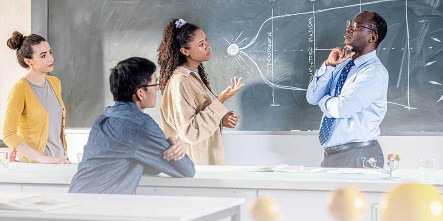 Um professor de ciências conversando com alguns de seus alunos.