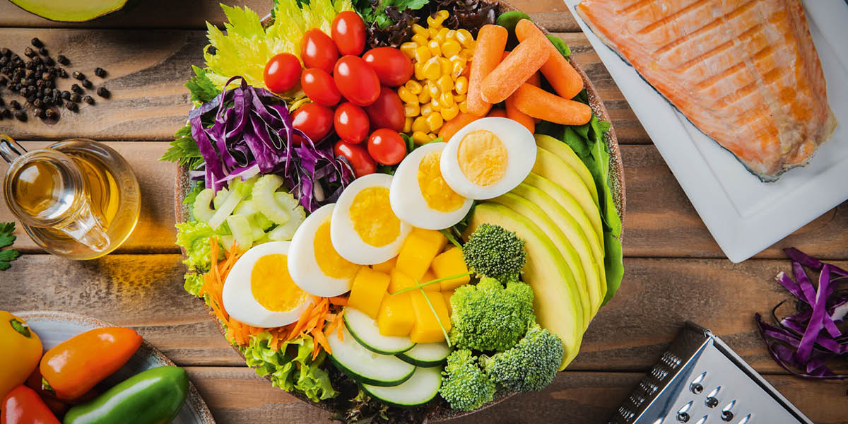 Vários tipos de alimentos saudáveis numa mesa.