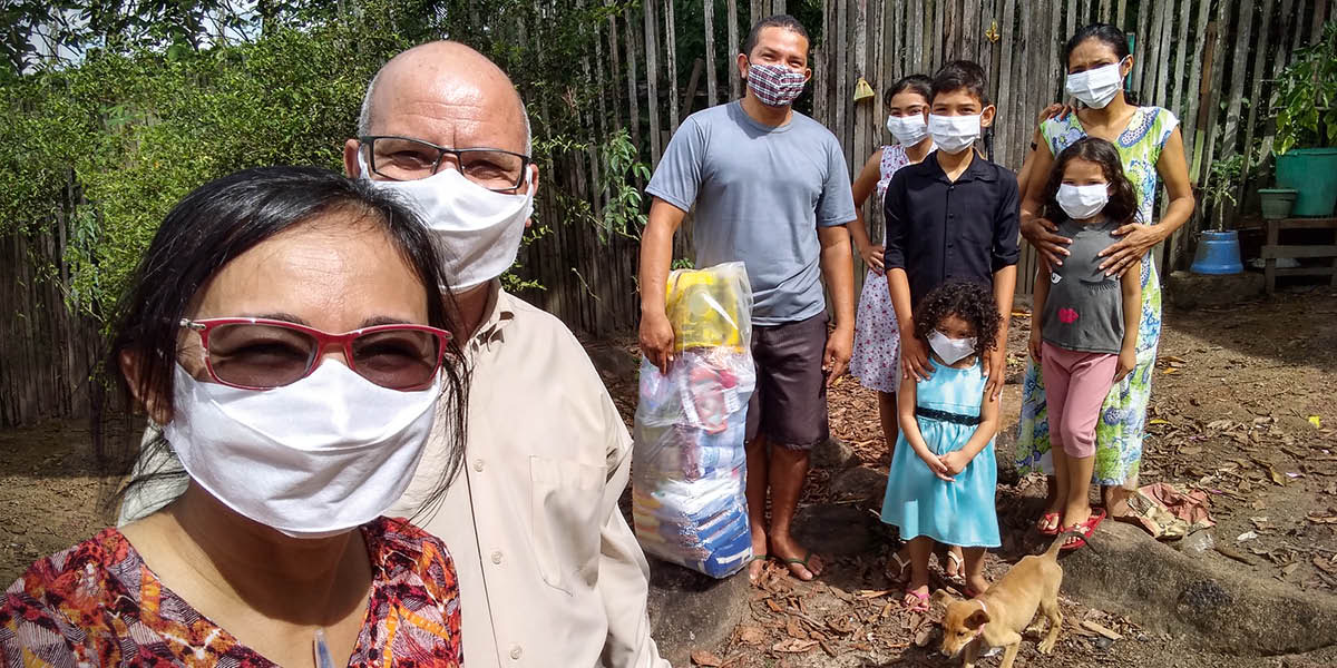 Irmãos e irmãs recebendo alimentos.