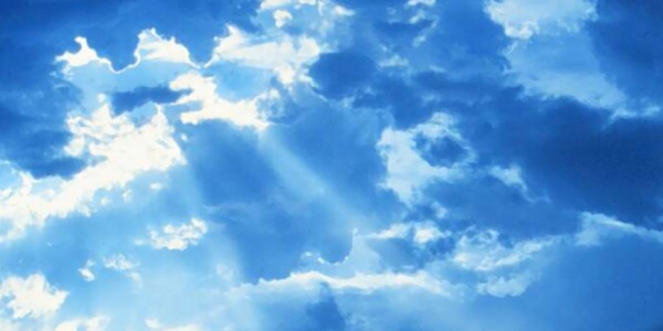 Os raios do sol brilhando entre as nuvens