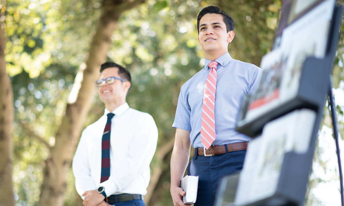 O mesmo jovem dando testemunho com o carrinho de publicações.