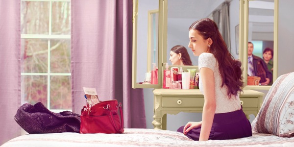 Pais observam enquanto sua filha adolescente olha para sua revista A Sentinela