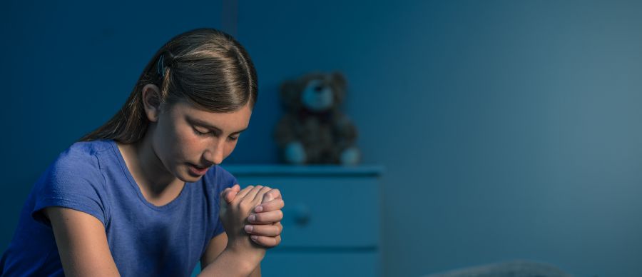 Uma menina se dedica a Deus em oração