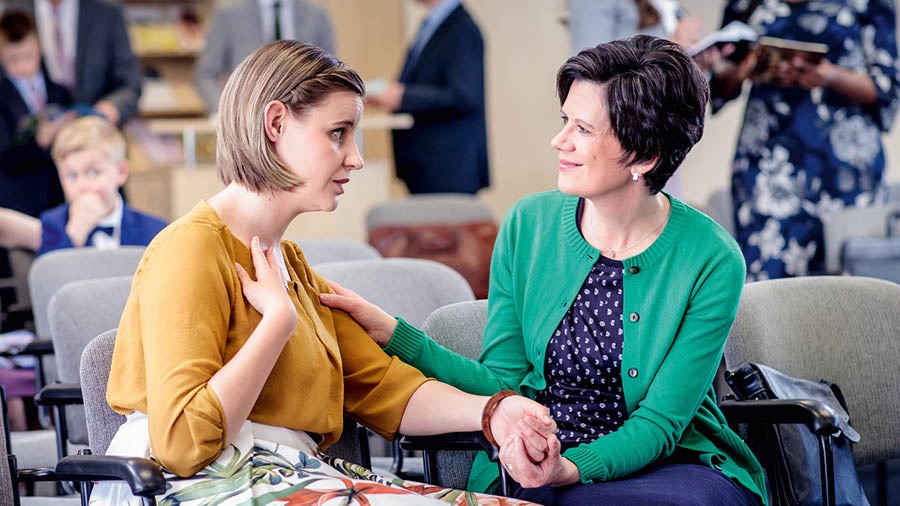 Duas irmãs conversam no Salão do Reino e fazem as pazes