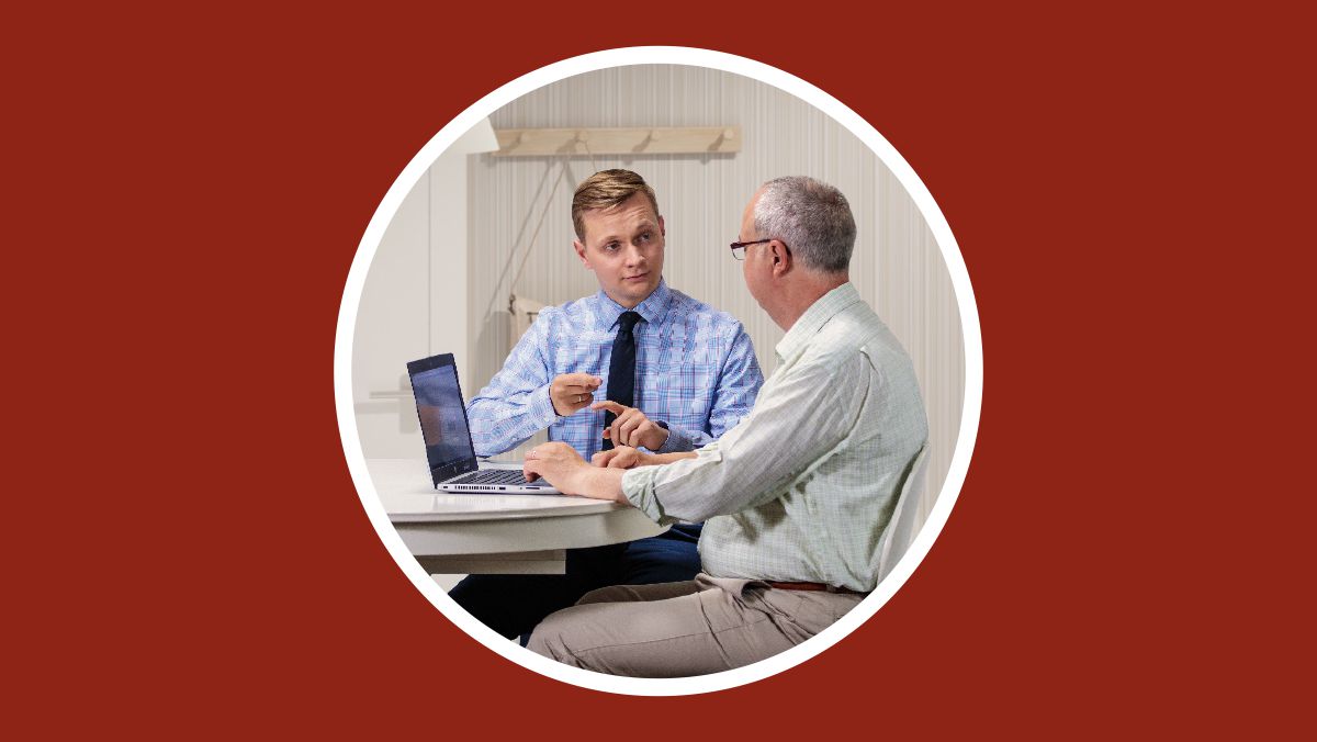 Um irmão ensina ao estudante como ele pode fazer pesquisas usando o computador.