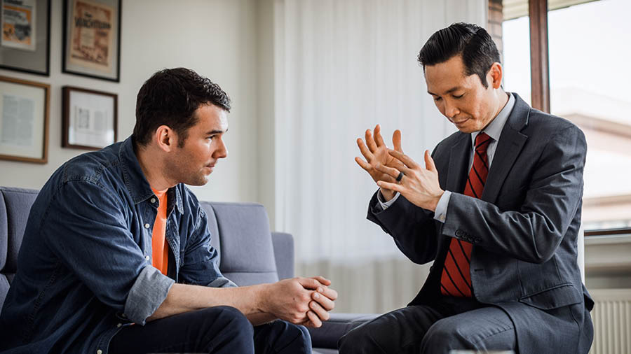 Um ancião orando com um irmão que voltou para Jeová.