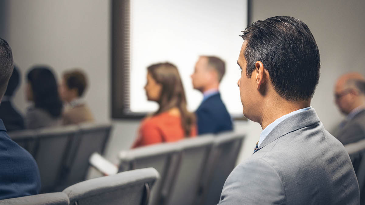 Um irmão observando um casal sentado junto na reunião.