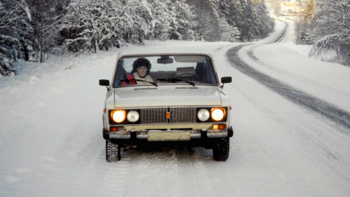 Lesli em um carro numa estrada coberta de neve.