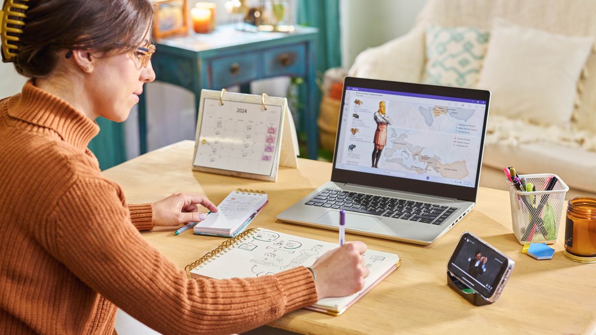 Uma irmã usando um notebook, uma Bíblia e um caderno para fazer seu estudo pessoal. Ela está usando o quadro “Potências mundiais preditas por Daniel” no Apêndice B9 da “Tradução do Novo Mundo”.