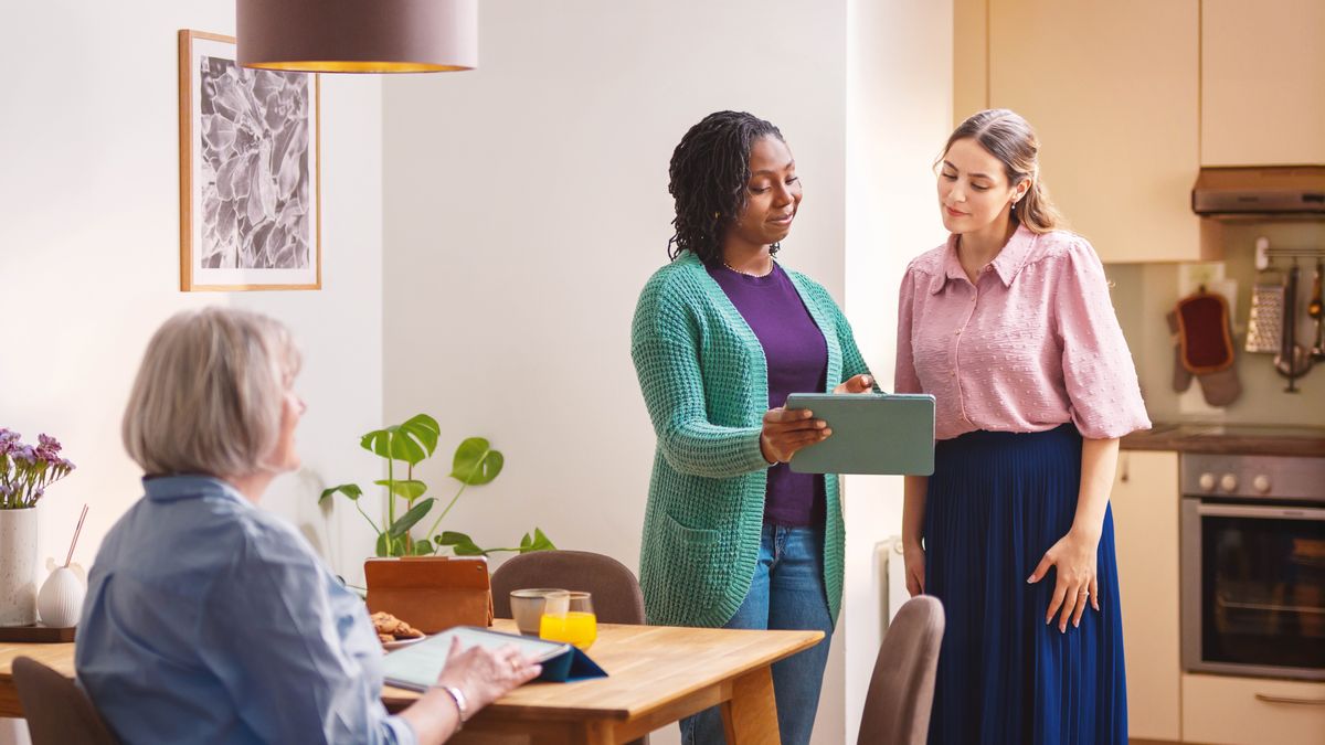 Uma irmã ajudando sua estudante a se preparar para a pregação durante o estudo. A estudante faz uma apresentação para a irmã usando o folheto “Onde encontrar as respostas mais importantes da vida?”.