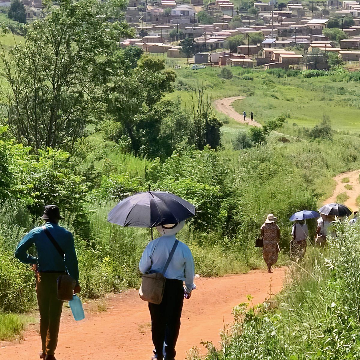 Franco no serviço de campo, andando até um povoado com um grupo de irmãos e irmãs.