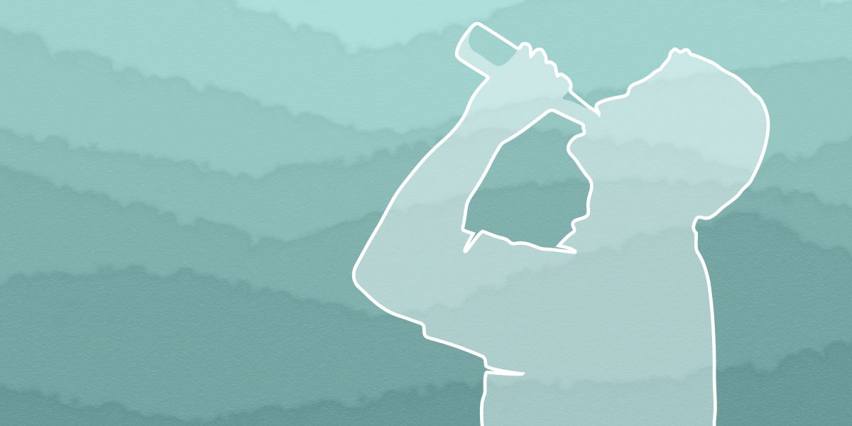 La silueta d’un home bevent d’una botella