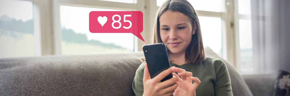 Una jove somrient i mirant el seu mòbil. Ha rebut 85 likes en la seua xarxa social.