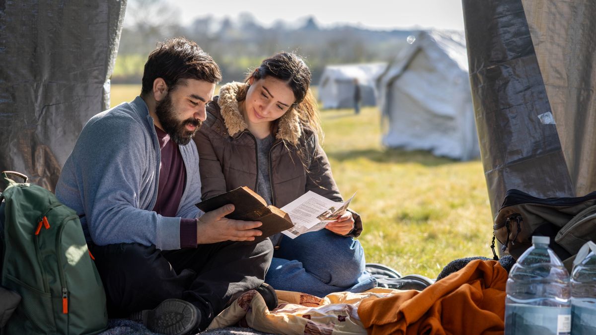 Una parella llegint la Bíblia junts en la seua tenda en el camp de refugiats.