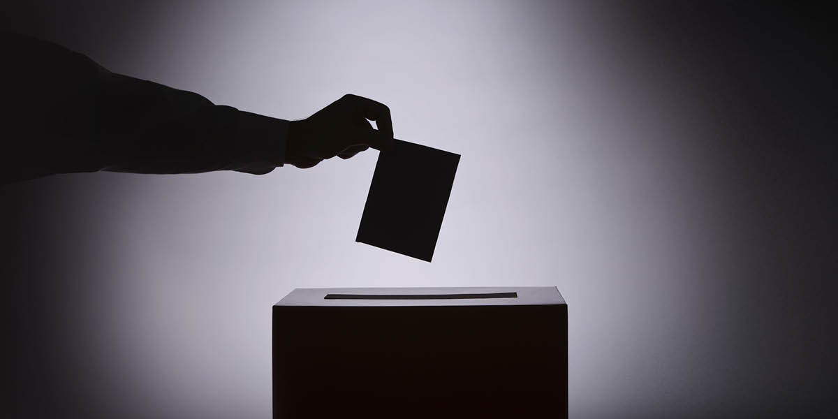 Algú deposita un vot en una urna electoral.