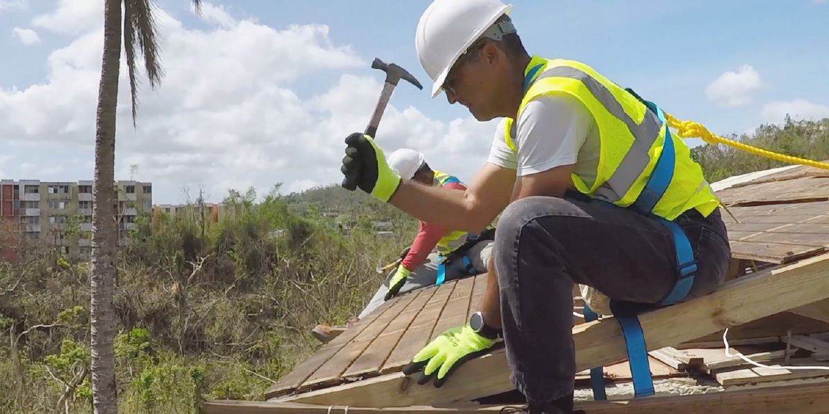 Germans reparant una teulada al Carib després d’un huracà