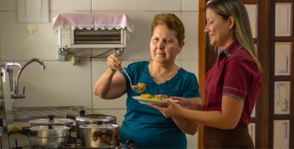 Si Maria Lúcia nagkuha sa iyang giluto para sa iyang higala.