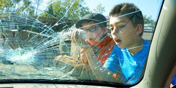 Duha ka batan-ong lalaki nga nagtan-aw sa windshield nga naigo sa ilang besbol