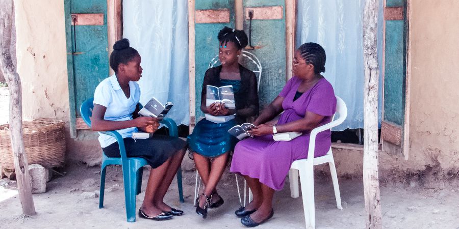 Si Gérole ug ang iyang anak nag-Bible study sa usa ka batan-on didto sa Haiti