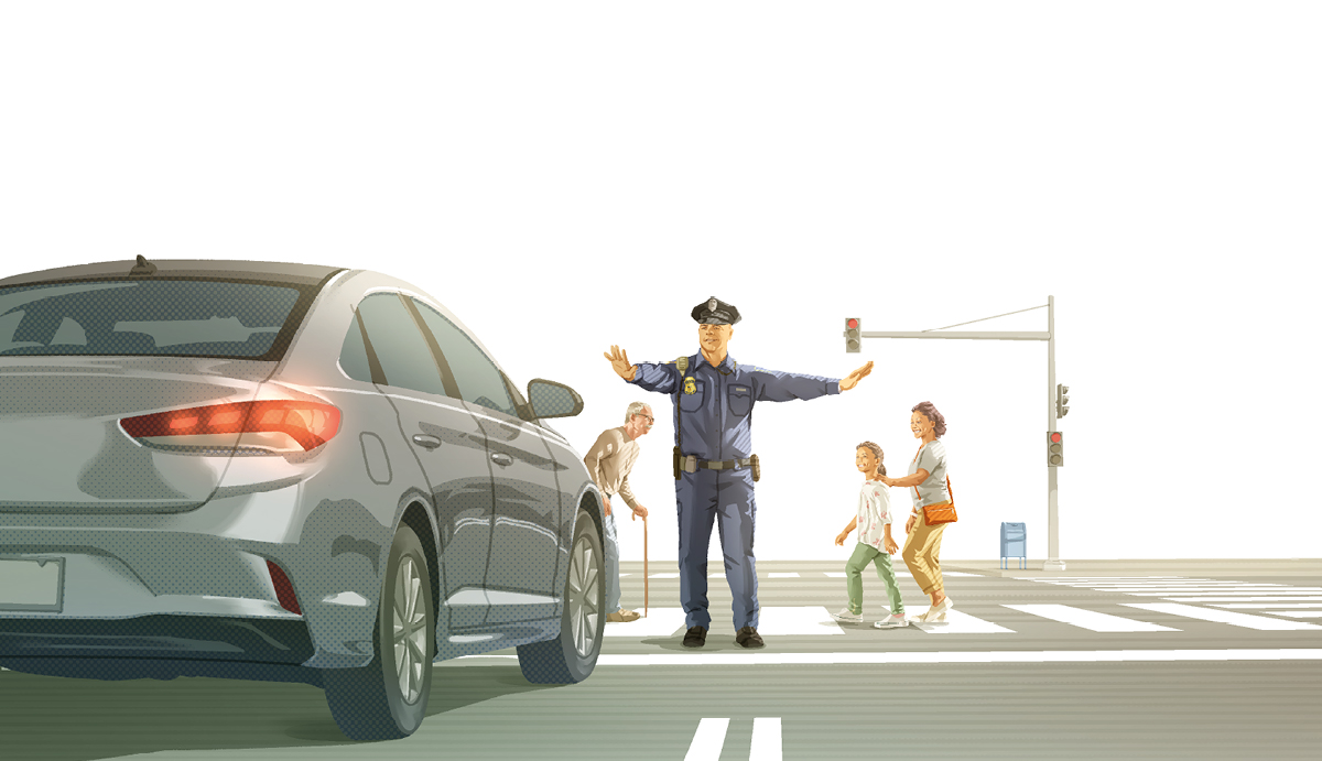 پۆلیسێک لە ڕێگایە‌کی قە‌رە‌باڵغدا هاتوچۆ ڕادە‌گرێت خە‌ڵکی تە‌مە‌ن جیاواز بە شە‌قامە‌کە‌دا دە‌ڕۆن.‏