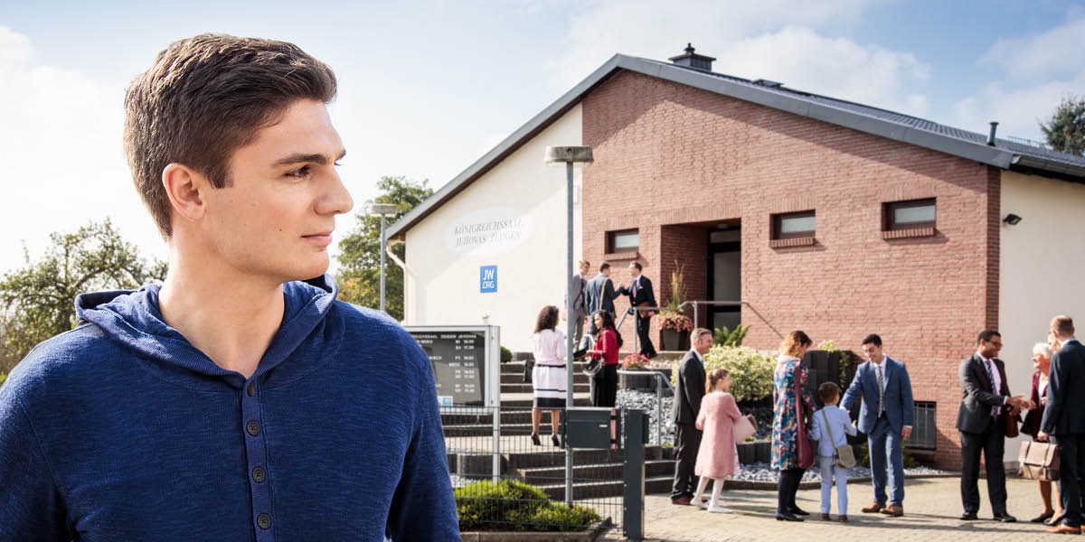 Mladý muž pozoruje lidi, kteří jdou do sálu Království