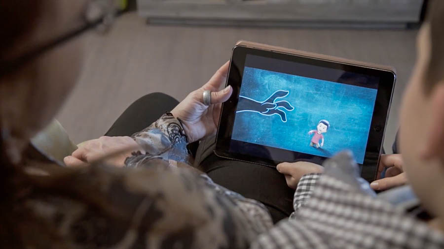 Scéna z videa „Postavte dům, který vydrží: Chraňte svoje děti před tím, ‚co je zlé‘“. Maminka se synem se dívají na video „Chraňte své děti“