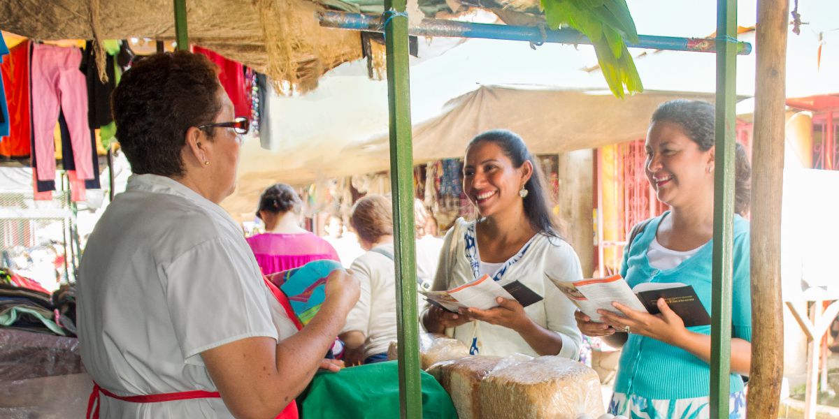 Dos hermanas le hablan de la Biblia a una vendedora en un mercado de la ciudad de Tipitapa (Nicaragua)