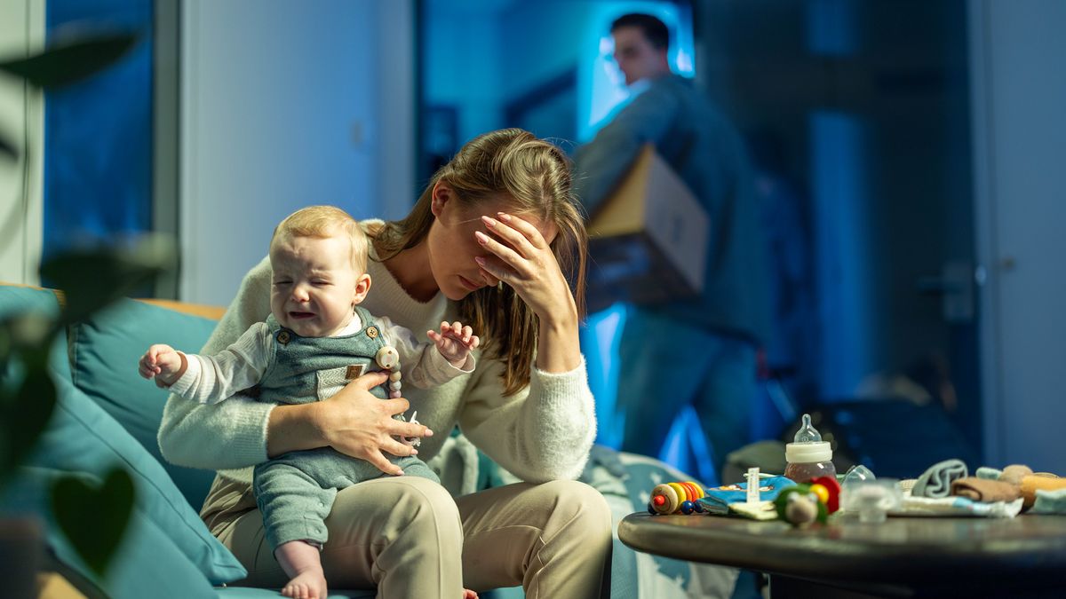 Kvinden fra det tidligere billede sidder med en grædende baby på skødet og tager sig til hovedet. Manden er ved at flytte ud med en flyttekasse under armen.