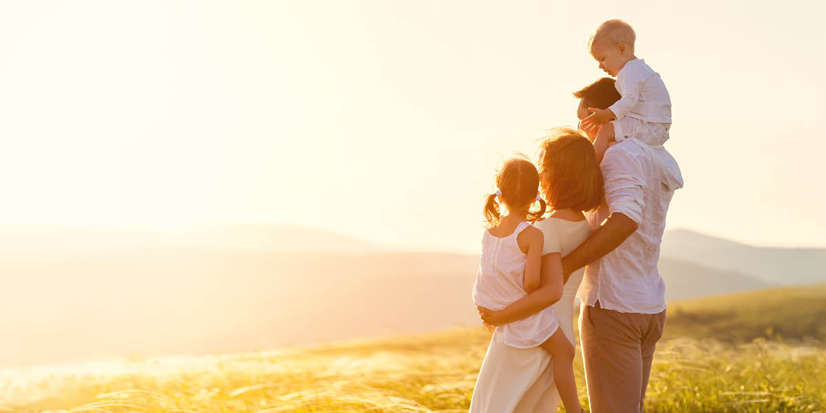 En lykkelig familie betragter solen i horisonten.