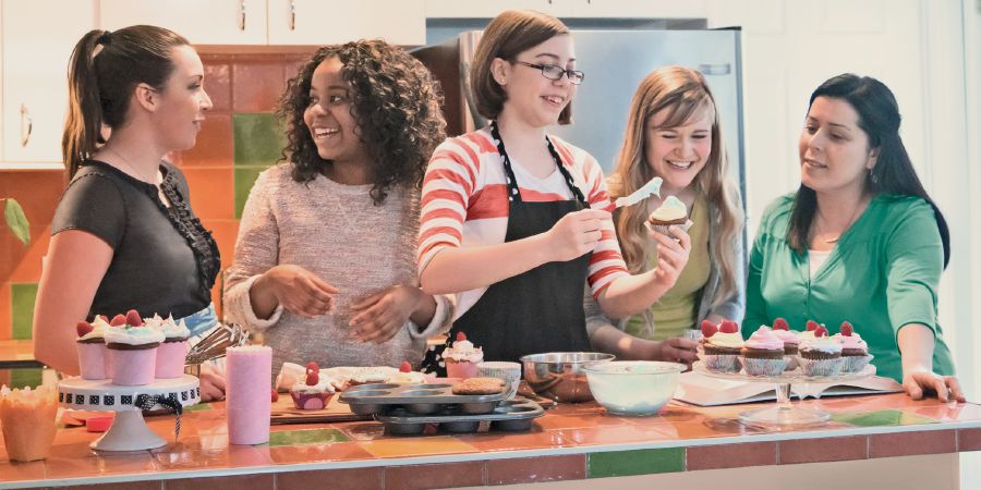 Teenagepiger der bager cupcakes sammen