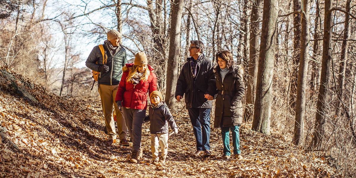 En familie går tur i skoven og nyder naturen