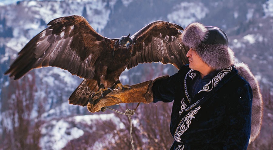Mann mit abgerichtetem Adler zum Jagen